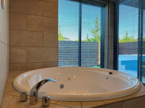 uma banheira na casa de banho com uma grande janela em Retreat Villa Aym - Vacation STAY 18153v em Minamiboso