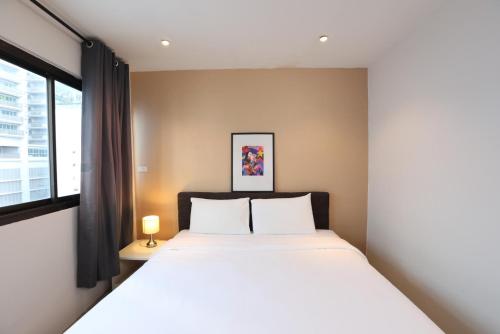 a bedroom with a large bed and a window at Studio F Sukhumvit in Bangkok