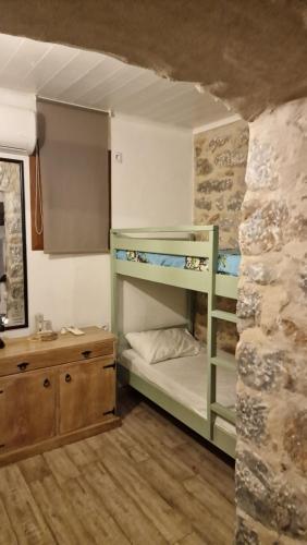 a room with bunk beds in a stone wall at the old bakery room in Kokkala