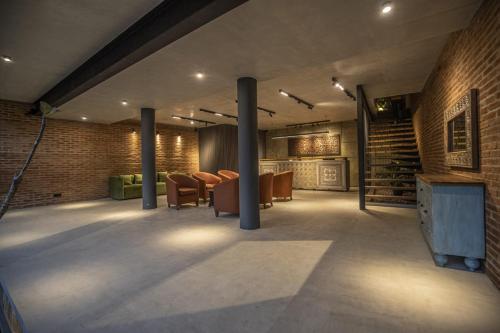 a lobby with chairs and a tv and a brick wall at Ella Heritage in Ella