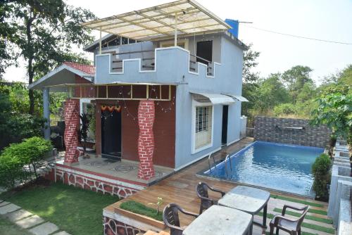 a house with a swimming pool in the backyard at ARNAV VILLA Farmhouse & Resort in Vajapūr
