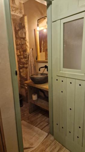 a bathroom with a sink and a mirror and a counter at the old bakery room in Kokkala