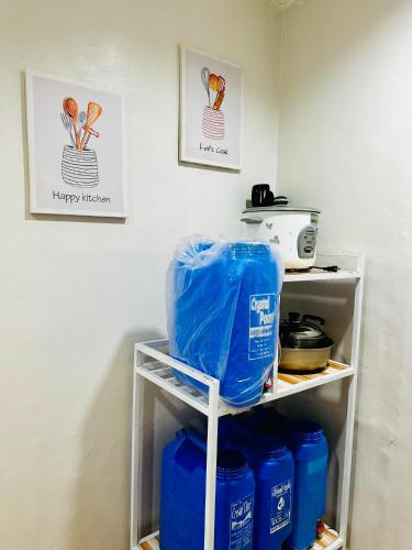 a shelf filled with blue gallon buckets in a kitchen at La Maison - Homestay near Clark Airport in Angeles