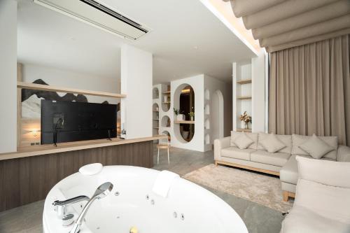 a living room with a white tub and a couch at Timberton Resort Khaoyai in Ban Tha Maprang