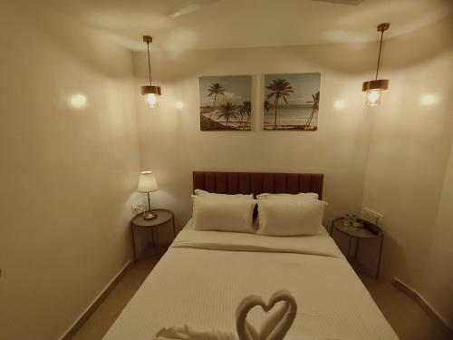 The Majlis Hotel - Colaba Mumbai في مومباي: غرفة نوم عليها سرير وقلب