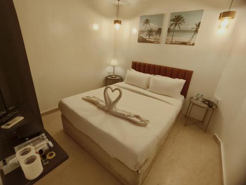 a bedroom with a bed with a swan decoration on it at The Majlis Hotel - Colaba Mumbai in Mumbai