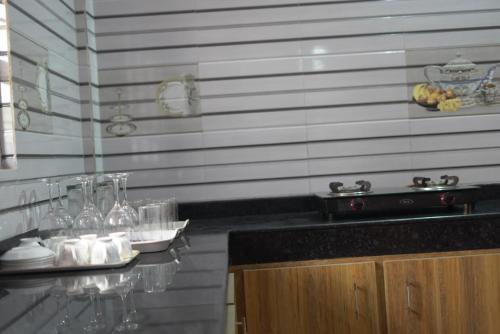 a counter with wine glasses on a counter top at Coorg Stream Side Homestay in Ponnampet