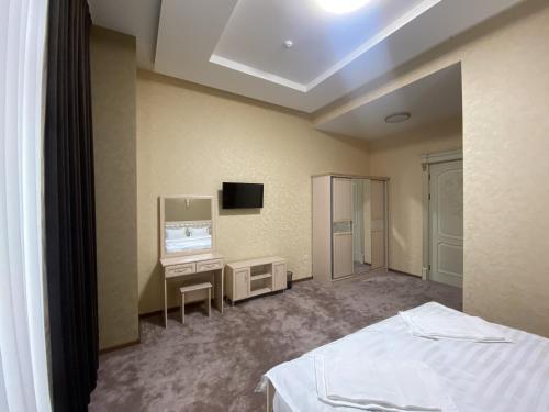 タシュケントにあるGRAND KARAVAN HOTELのベッドルーム(ベッド1台、デスク、テレビ付)