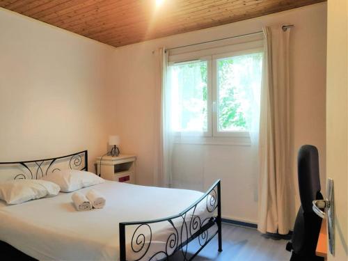 a bedroom with a large bed with a window at Le clos Fleuri in Lescar