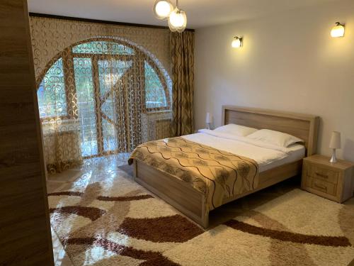 um quarto com uma cama e uma grande janela em Casa Cristian em Sinaia