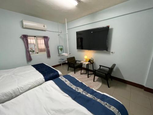 鹿港的住宿－鹿港宏旭民宿，一间卧室配有一张床和一台平面电视
