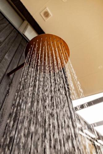 a shower head with water coming out of it at Winston's Beach House in Bicheno
