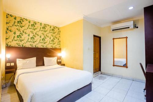 ein Schlafzimmer mit einem großen weißen Bett in einem Zimmer in der Unterkunft Hotel Galaxy Waena in Sentani