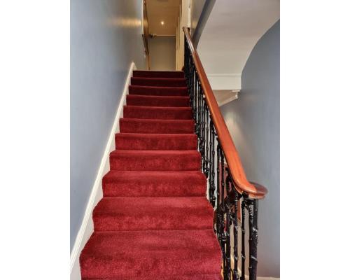 een rode trap met vloerbedekking en een rood tapijt bij FG1- Ground Flr Flat Good for 4- Near Hyde Park in Londen