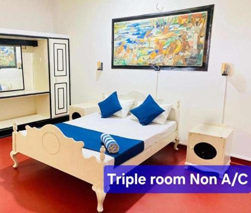 a bedroom with a bed and a painting on the wall at Hotel Mount Lanka in Watumulla