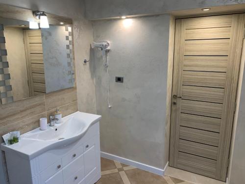uma casa de banho com um lavatório branco e um chuveiro em Casa Cristian em Sinaia