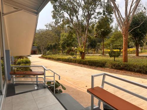 a porch with two benches and a skateboard on a sidewalk at Nakra Hill Mae on in Ban On Luai