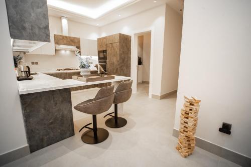 a kitchen with two bar stools and a counter at SAQEEFA 9 - A01 - Self Entrance in Riyadh