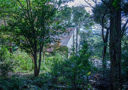a house in the middle of a forest with trees at kamenos Luxury Resort With Beautiful Scenery Hiji in Hiji