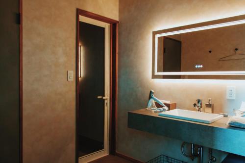 a bathroom with a sink and a mirror at Villa CORTILE in Awaji