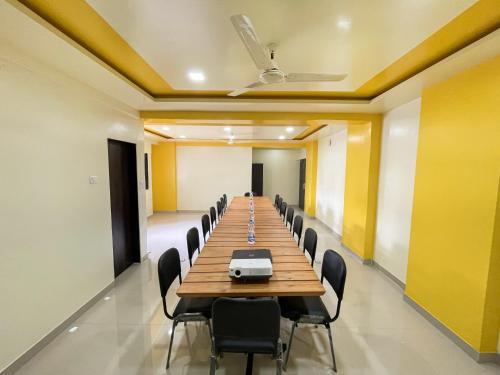 a long conference room with a long table and chairs at Hotel Bramha Inn Aundh Wakad Rooms Restaurant Banquet in Dāpuri