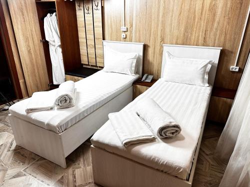 Dos camas en una habitación con toallas. en Bal-Meyir Hotel en Almaty