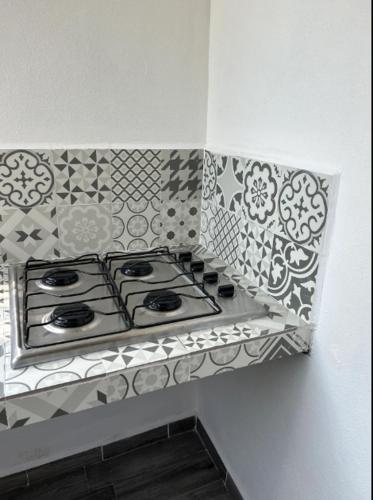 a kitchen counter with a stove top in a wall at Departamento Amueblado con Alberca Pedregal B in Tamasopo