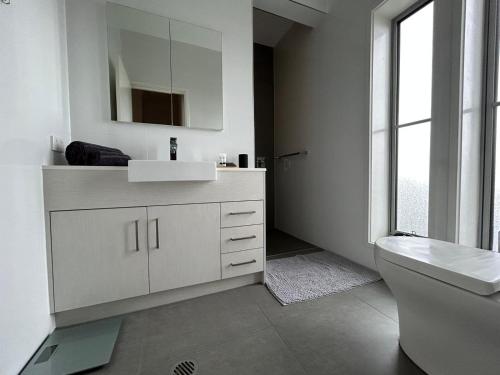 a white bathroom with a sink and a toilet at Mermaid - Magic king unit in Gold Coast