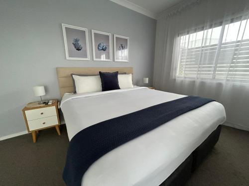 um quarto com uma grande cama branca e uma janela em Mermaid - Magic king unit em Gold Coast