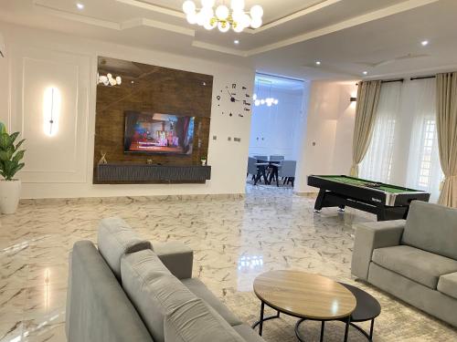 a living room with a couch and a pool table at Luxe Haven Lekki in Lekki