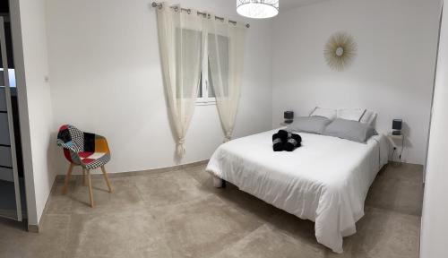 um quarto branco com uma cama branca e uma cadeira em Villa pedicervu haut em Ventiseri