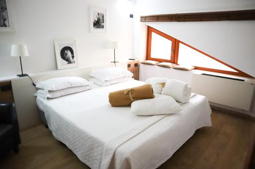 a bedroom with a bed with white sheets and a bag on it at Villa Alba Boutique Hotel in Pescara