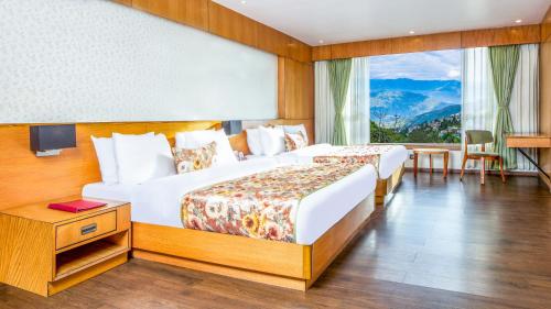 Habitación de hotel con 2 camas y ventana en Summit Montana Suites & Spa, en Darjeeling