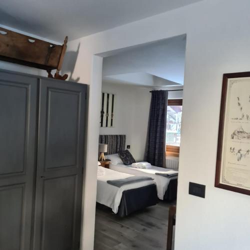 a hotel room with two beds and a window at Hotel Dente Del Gigante in Courmayeur