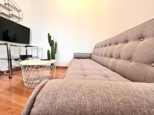 un divano in soggiorno con cactus di ComeCasa 2 bedrooms Larga apartment a Milano