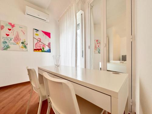una sala da pranzo bianca con tavolo e sedie bianchi di ComeCasa 2 bedrooms Larga apartment a Milano