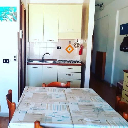 a small kitchen with a table and a sink at Lampedusa Low Prices in Lampedusa
