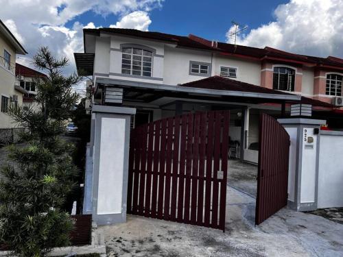 a house with a wooden gate and a fence at 温馨舒适民宿芙蓉市区 Sri Pulai Homestay @ Seremban in Seremban