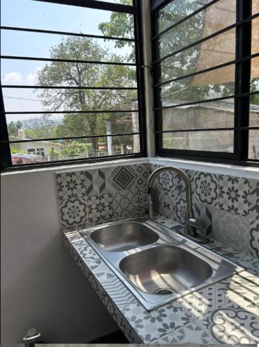 a kitchen counter with a sink and a window at Departamento Amueblado con Alberca Pedregal B in Tamasopo