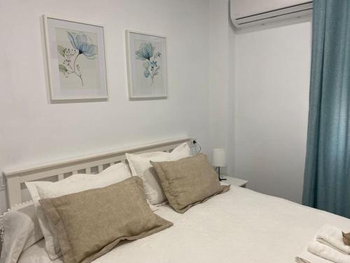 a bedroom with a bed with two pictures on the wall at Alojamiento Baeza California 4B in Baeza
