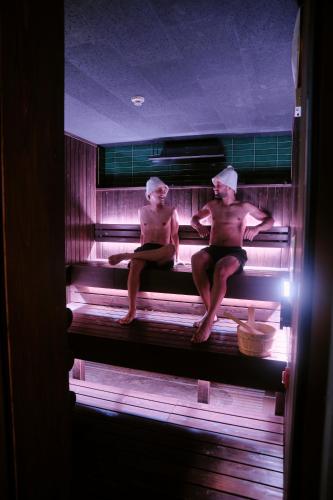 two shirtless men sitting in a sauna at FAV LUX Hida Takayama in Takayama
