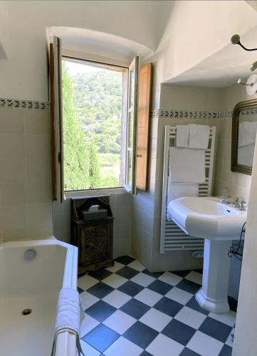 une salle de bain blanche avec un lavabo et une fenêtre dans l'établissement Hotel Palazzu Pigna, à Pigna