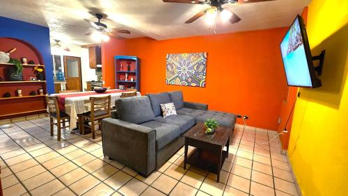 a living room with a couch and a tv and a table at Casa Revolucion: 2BR/2Ba Casita close to downtown with private parking in Cabo San Lucas