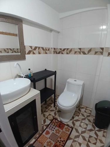 a bathroom with a white toilet and a sink at Stanley House Seaview Apartments in Panglao