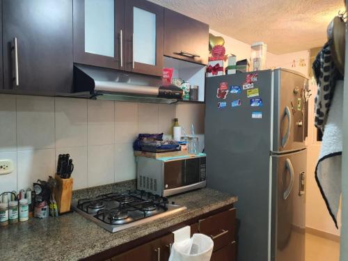 a kitchen with a stove and a refrigerator at Apto Torres de Montreal in Barranquilla