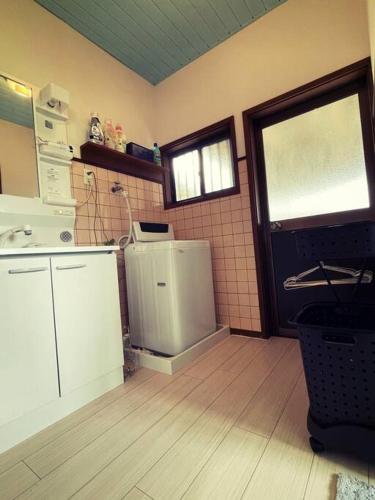 a kitchen with a white refrigerator and a window at yadori TEN 宿り　甸 in Matsubara