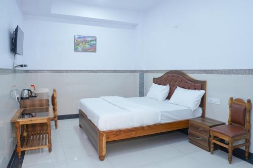 a bedroom with a bed and a desk and a chair at Lemon Hotels in Jamshedpur