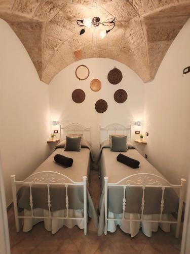a bedroom with two beds in a room with a ceiling at Stella House in Fasano