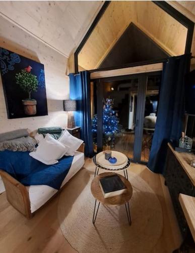 - un salon avec un lit et un arbre de Noël dans l'établissement LA MAISON UGOLIN and INÈS, à Baccarat