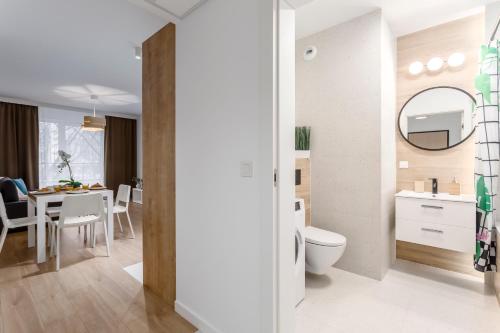 a bathroom with a toilet and a dining room at Warsaw City Family Premium in Warsaw